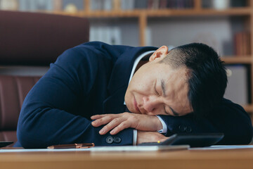 Asian businessman sleeping tired lying on the table, man at work