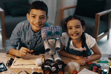 Wall Mural - If your dream it you can build it. Portrait of two adorable young siblings posing with their newly built toy robot at home.