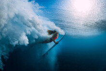 Surfer Woman With Surfboard Dive Underwater With Under Big Wave.
