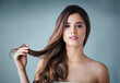 © Nola Viglietti/peopleimages.com - Healthy hair is a must. Studio portrait of a beautiful young woman posing against a gray background.
