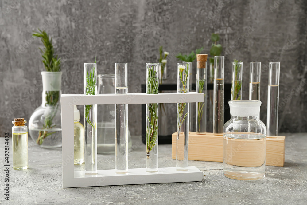 Test tubes with natural essential oils on grunge background
