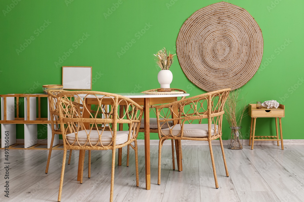 Vase with dry reeds on dining table in stylish room