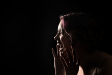 Silhouette Of Screaming Young Woman On Black Background