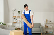 © Pixel-Shot - Male worker with rolled wicker carpet in room