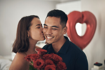 Wall Mural - Love lives here. Shot of a young woman kissing her husband on the cheek at home.