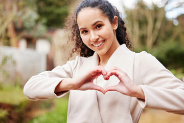 Poster - Ive got a love of learning. Portrait of an attractive young female university student making a heart shape with her hands while standing outside on campus.