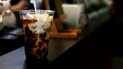 Wall Mural - Barista pouring milk into a glass of iced coffee