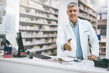 Canvas Print - What can I do for you today. Portrait of a cheerful mature male pharmacist reaching out to give a handshake while looking at the camera.