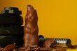 Dumbbell barbell weight plates crushing Easter chocolate bunny. Healthy fitness lifestyle composition, gym workout and fit training concept with copy space. Cheat day temptation vs sticking to diet.
