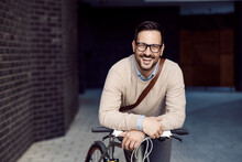 An Urban Man Posing With Bicycle And Smiling At The Camera.