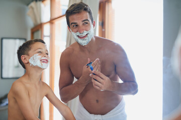 Wall Mural - And soon...all the hair will be gone. Cropped shot of a handsome young man teaching his son how to shave in the bathroom.