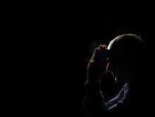 Young Man Praying On Dark Background