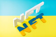 © Lazartivan - NFT inscription with white 3d letters on a blue-yellow background. Non-fungible token against background of colors of the Ukrainian flag. Crypto art concept