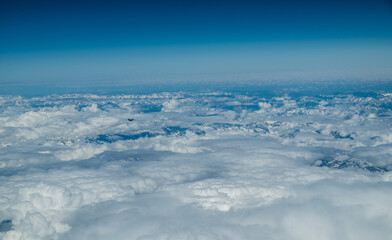 Wall Mural - White heavy clouds in the blue sky. Panoramic cloudscape above the clouds.