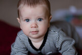 Fototapeta  - Portrait Of white Baby Toddler Smiling Sitting On Bed Indoor