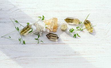 gemstones and spring snowdrops flowers on white wooden background. minerals for esoteric spiritual practice, soul relaxation, meditation, witchcraft. Magic crystal ritual for life balance, harmony