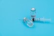 © xy - Syringe and covid-19 vaccine on blue background