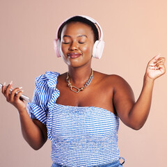 Poster - Music, a universal language. The universal healer. Studio shot of a young woman using a smartphone and headphones against a pink background.