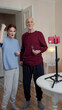 © iaginzburg - The woman starts recording on the phone and greets the viewer. her grandfather also participates in the stream and hugs the girl