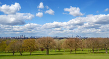 View Of London Seen From Sydenham Hill In Dulwich. L-R: Croydon, Elephant And Castle, And City Of London. Trees, Grass, Blue Sky And Clouds.