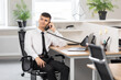 © Olga - young man in a white shirt with a black tie at the table in a bright office calls