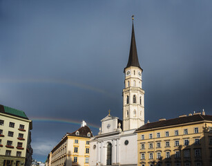 Wall Mural - Saint Michael Church at Saint Michael Square (Michaelerplatz) with a rainbow in the sky - Vienna, Austria