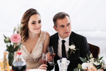 Poster - Wedding couple in the park. An elegant bride of European appearance and a groom in a black suit.