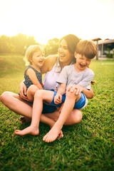 Filling their days with laughter and fun. Shot of a mother bonding with her two adorable little children outdoors.