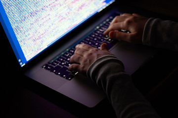 Close-up woman software developer hands. Programmer working in the dark at night