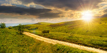 Carpathian Mountain Landscape In Summer At Sunset. Dirt Road And Hiking Trail Track. Panoramic View Of A Hilly Countryside In Evening Light. Vacation And Active Lifestyle Concept