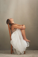 Wall Mural - Dont believe everything you think. Studio shot of an attractive young woman looking depressed while sitting on a chair.