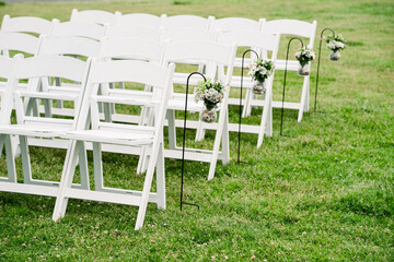 white wedding chairs on the grass