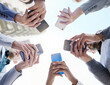 © Matthew C/peopleimages.com - Connecting faster for the best way forward. Shot of a group of unrecognisable businesspeople using their cellphones together at and outside meeting.