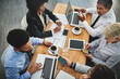 © Delmaine Donson/peopleimages.com - Working from their multiple devices. Shot of a group of businesspeople having a meeting in an office.
