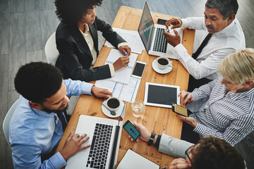 Aufkleber - Working from their multiple devices. Shot of a group of businesspeople having a meeting in an office.