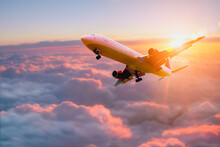 Passenger Airplane. Passengers Commercial Airplane Flying Above Clouds In Sunset Light. Business Trip. Commercial Plane. Concept Of Fast Travel, Holidays And Business.