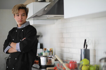 Asian cook in the kitchen prepares food in a cook suit