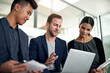 © Cecilie S W/peopleimages.com - Going over their presentation. Cropped shot of three colleagues working in the office.