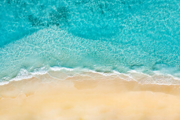 Wall Mural - Summer seascape beautiful waves, blue sea water in sunny day. Top view from drone. Sea aerial view, amazing tropical nature background. Beautiful bright sea with waves splashing and beach sand concept