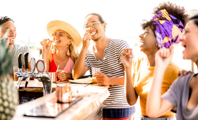 multiracial trendy friends having fun drinking bear at sunset beach party - summer joy and life styl