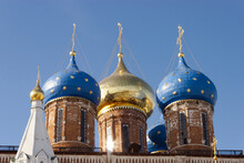Three Golden Orthodox Bright Crosses Are On Top Of Blue And Golden Cupolas On The Top Of The Stone Church Against Blue Dark Sky