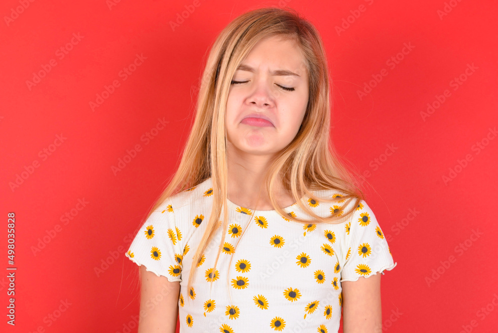 Dismal gloomy rejected blonde little kid girl wearing daisy t-shirt red ...