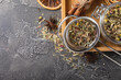 Herbal tea in a brewing strainer on a black textured background. Detox and tea for immunity. Herbal collection of chamomile, mint, lemon balm. pieces of wild rose and dried fruits.
