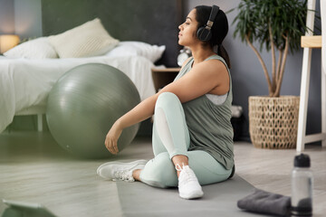 Each day is a new chance to change your life. Shot of a sporty young woman listening to music while exercising at home.