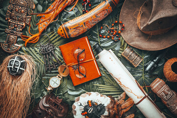Fototapete - Travel equipment and items related to the diverse ethnic culture in the world / concept of an expedition or treasure hunt, tropical leaves background