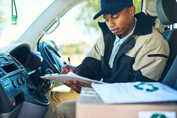 Poster - Ive got just a few more stops to make. Shot of a courier writing on a clipboard while sitting in a delivery van.
