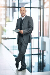 Wall Mural - I use my tablet instead of my laptop for presentations. Shot of a mature businessman using his digital tablet at the office.