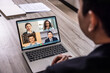 © jayzynism - Back view of businessman speak using video conference on laptop with diverse colleagues. online briefing work from home
