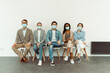 © Kostiantyn - Colleagues in face masks sitting on chairs