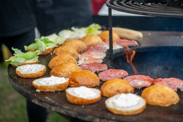 Wall Mural - Burger buns and patties are grilled outdoors. Burger bbq